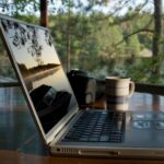 Laptop auf einem Holztisch an einem See