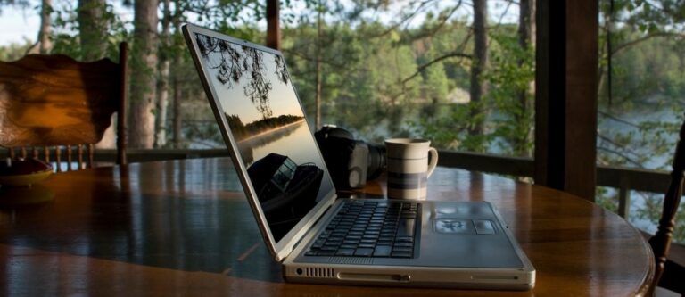 Laptop auf einem Holztisch an einem See