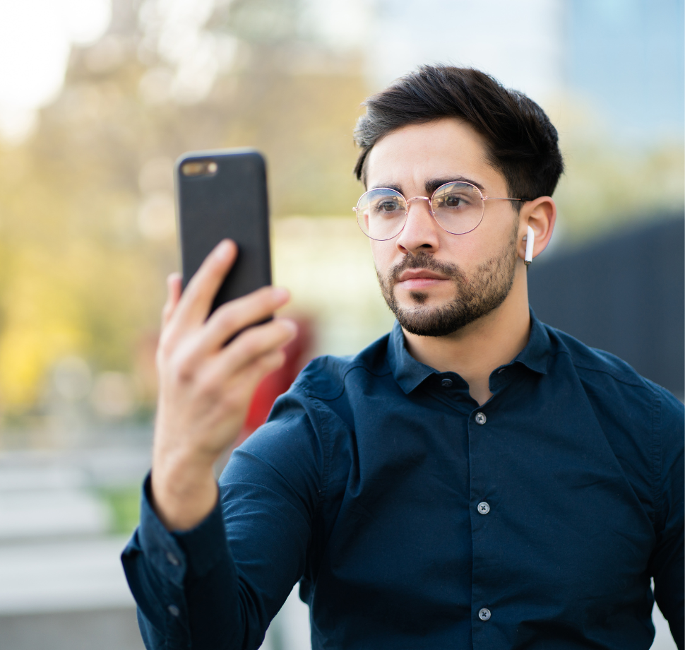 Mann mit Handy und Kopfhörern scheint am Videotelefonieren zu sein